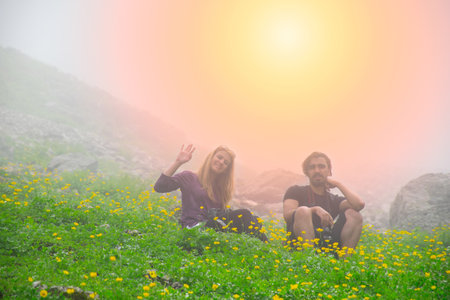 Young photographers resting on the grass in a foggy environment.の写真素材