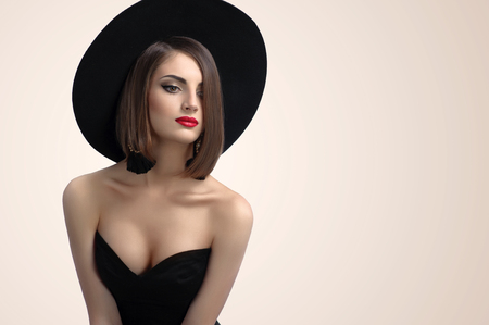 beautiful girl with makeup in hat and earringsの写真素材