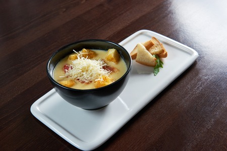 The Cheese soup. Top view of a delicious cheese soup with salami and croutonsの写真素材