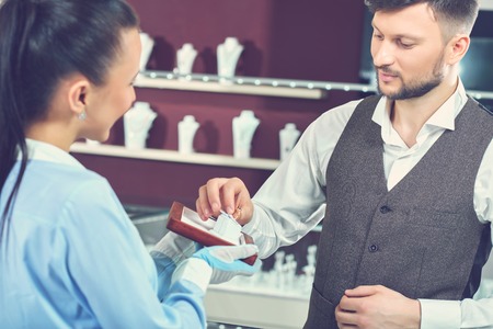 Young man choosing present at jewelry store.の写真素材