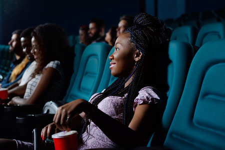 Young African woman watching a movieの写真素材