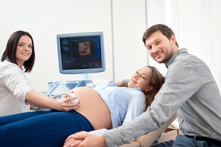 Parents expecting of child and diagnosing with ultrasound.の写真素材