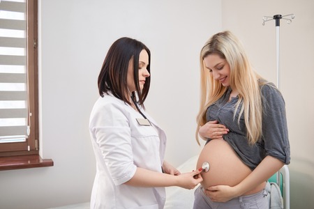 Pregnant woman having ultrasonic scanning at the clinicの写真素材