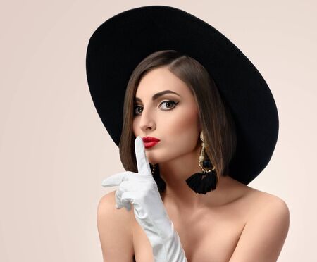 Elegant fashionable woman posing wearing a hat in studioの写真素材