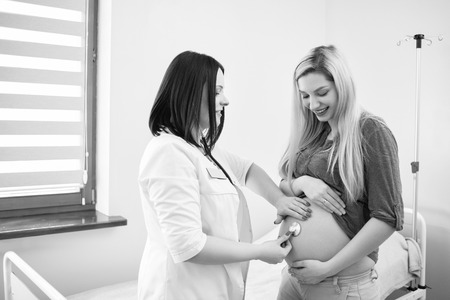 Pregnant woman having ultrasonic scanning at the clinicの写真素材