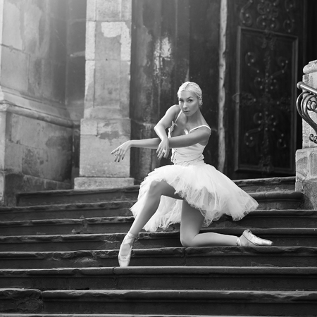 Young ballerina woman posing on stairsの写真素材