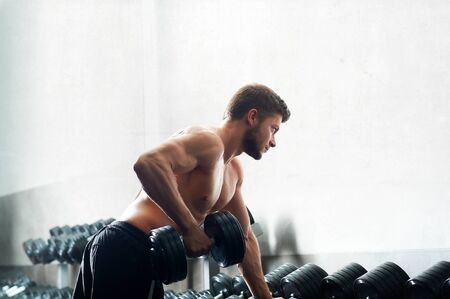 Handsome young athlete working out at the gymの写真素材
