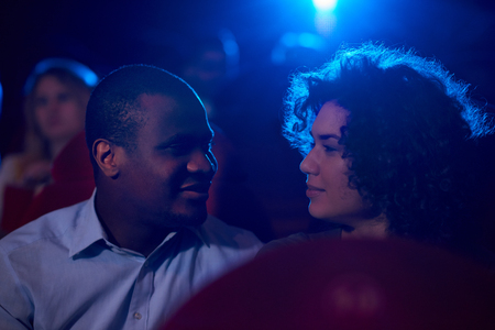 Young loving couple sharing romantic moment at the cinema
