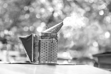 Old fashioned metal bee smoker at the apiary