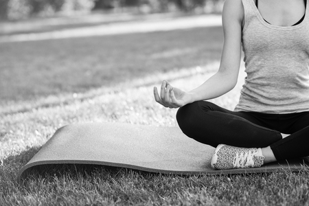 Young woman practicing yoga outdoors at the parkの写真素材