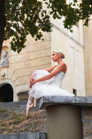 Beautiful graceful ballerina dancing on the streets of an old ciの写真素材