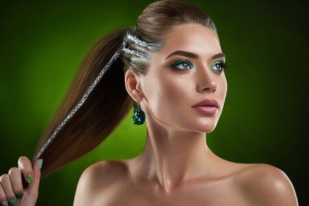 Confident beautiful brunette girl with stylish haircut and green shiny makeup.