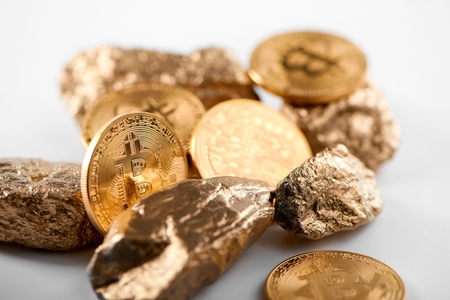 Encrypted golden bitcoin together with gold lumps representing most important finance trends worldwideの写真素材