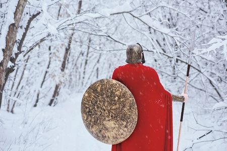 Close up of spartan man standing in winter forest .の写真素材