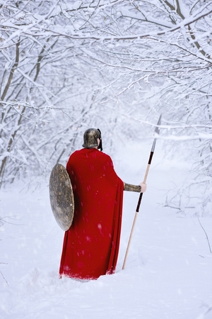 Close up of spartan warrior walking through winter forest .の写真素材