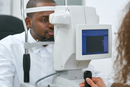 Patient looking at medical apparatus during vision checking in ophthalmological laboratory.Trying to...