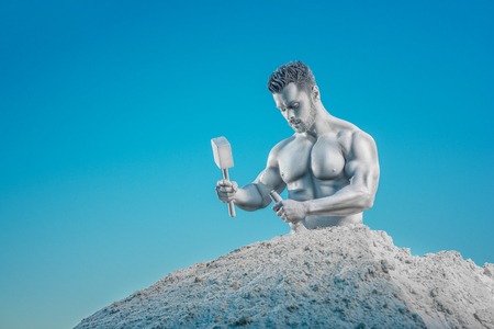 Crop of Atlas with hammer and chisel hollowing rock around himself. Portrait of young handsome silver skin man with half of his body in mountain creating his body. Concept of sport and workout.の写真素材