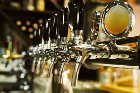 Close up of beer tap in row. Metallic equipment for bar and mini brewery. Concept of modern equipment.の写真素材