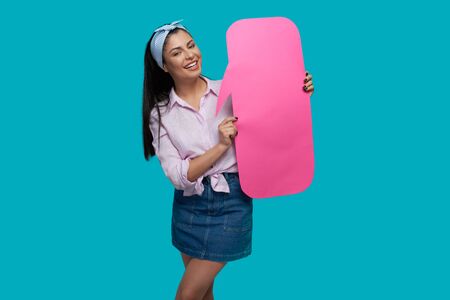 Front view of cheerful female teenager looking at camera while keeping clouds for ideas and messages...