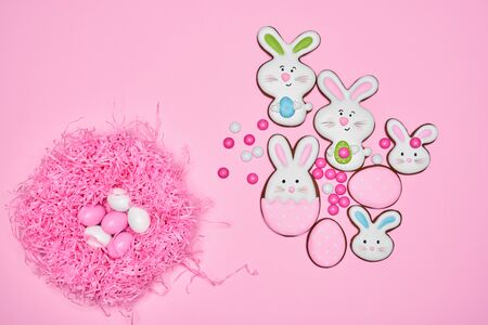 From above view of small chocolate balls in crispy sugar shell isolated on pink background. Easter...