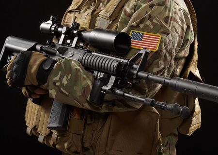 Front view of incognito military officer holding sniper rifle. Crop of american soldier in uniform...