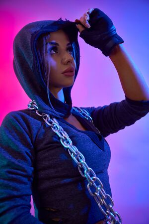 Side view of young sexy girl with perfect body holding chain on neck. Crop portrait of fitnesswoman...