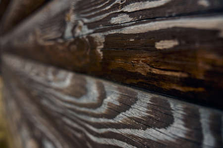 Rustic texture on wall outdoors, side view, dark background. Selective focus of brown old volume rough wooden planks, amazing natural pattern for design and decoration. Concept of natural decor.の写真素材