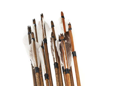 Closeup view of ancient wooden arrows with grey feathers isolated on white background. Qualitative...
