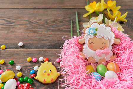 Beautiful festive composition of decorative nest, gingerbread eggs and chicken, chocolate round...