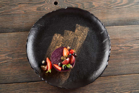 From above view of round piece of traditional blueberry cheesecake served with blueberries and...