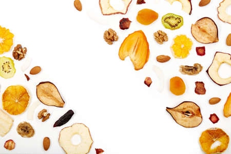 Above view composition of dried fruits apples, orange, persimmon, kiwi, apricots and nuts on white...