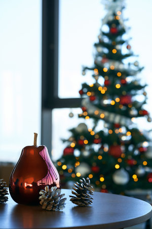 Round wooden table with festive decoration and blur background christmas tree. Modern apartment with beautiful decor. Winter holidays.の写真素材