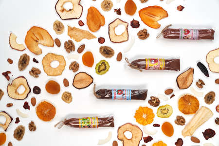Above view of fruit and berries lozenge different colors in beautiful packaging and almonds, orange,...