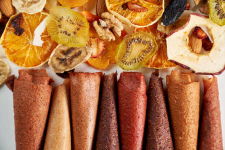 Above view of tasty fruit and berries lozenge different colors orange, dried apricot, raisins, walnuts, dried apples and kiwi on white background. Concept of healthy assorted dried fruit for snacks.の写真素材
