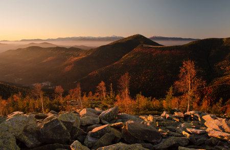 Autumn landscape with mountains,trees,and boulders at sunriseの写真素材