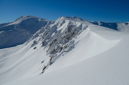 Panoramic view of snowy mountains in clear winter dayの写真素材