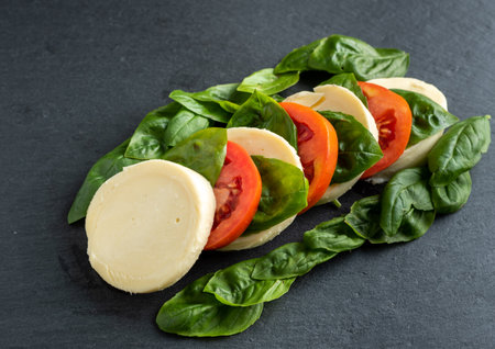 tomato basil mozzarella garlic on a dark backgroundの写真素材
