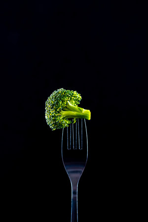 Broccoli on a fork on a black background. studio shot.