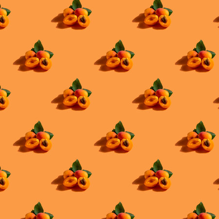 Seamless pattern with apricots on orange background. Flat lay, top viewの写真素材