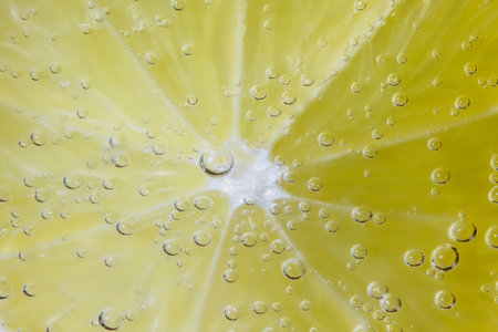 Lemon with water drops on a yellow background. Close up.の写真素材