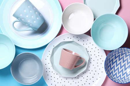 Empty ceramic tableware. Ceramic plates and cups on pink and blue background. Set of different modern white and blue plates,bowls and cups.Top view, flat lay.Copy space.の写真素材