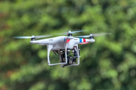 Quadcopter, quadrotor, drone on a green background. The unmanned radio-controlled aircraft flying on a green background of foliage.の写真素材