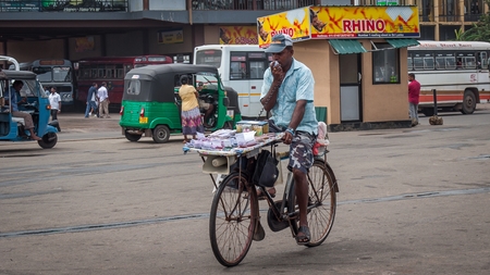 Matara, Sri Lanka, 27 May 2016: The seller of lottery tickets on a bicycle on the square near the central bus station of the city of Matara. Iprovizirovany office on wheels.のeditorial素材