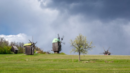National Museum Pirogovo in the outdoors near Kiev. Ancient traditional wooden windmill, spring landscape. National architecture.のeditorial素材