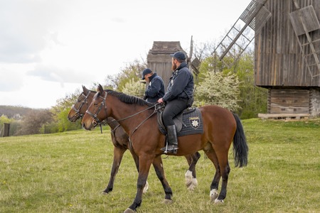 Kyiv, Ukraine - April 23, 2017: Policemen on horseback, a beautiful spring landscape, mounted police, horsemen in the countryside, outdoors. National Museum Pirogovo in the outdoors near Kiev.のeditorial素材