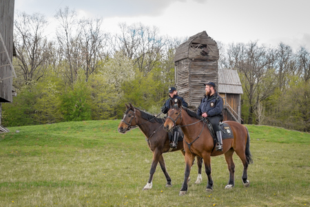Kyiv, Ukraine - April 23, 2017: Policemen on horseback, a beautiful spring landscape, mounted police, horsemen in the countryside, outdoors. National Museum Pirogovo in the outdoors near Kiev.のeditorial素材