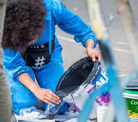 Ukraine, Nikolaev, 24.06.2017: Festival of graffiti dedicated to the Day of Youth. The central square of the city. Young beautiful African-American girl Sandra Sambo is preparing to draw graffiti.のeditorial素材
