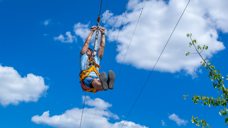 Ukraine, Migea - July 30, 2017: Zipline. A view of a blue sky with white clouds. Extreme and active rest.のeditorial素材