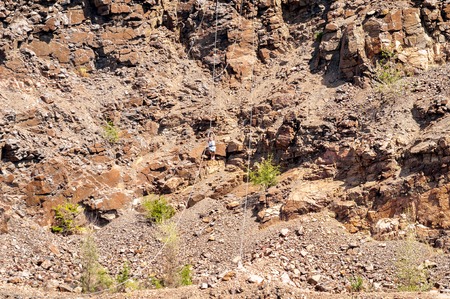 Ukraine, Migea - July 30, 2017: Zipline. The woman in the equipment slides on a steel cable. Trolley Track Over the lake. Extreme and active rest.のeditorial素材