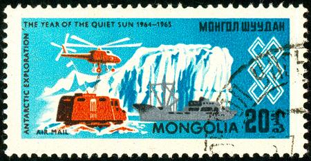 Ukraine - circa 2018: A postage stamp printed in Mongolia shows Helicopter, ship, dwelling, ice and the inscription Antarctic exploration. Series: International Year of the Sun. Circa 1965.のeditorial素材